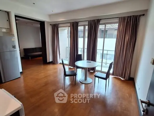 Spacious living room with wooden flooring and balcony access