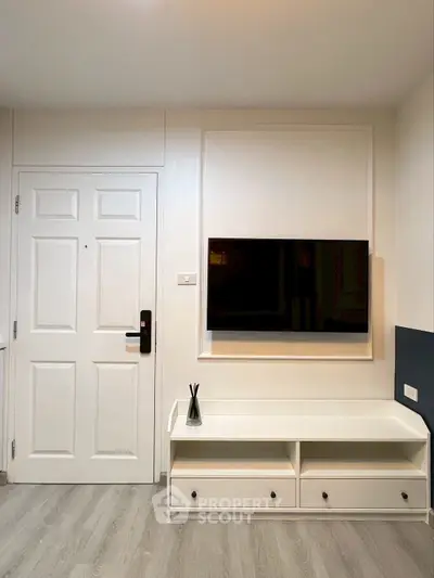 Modern living room with wall-mounted TV and stylish white furniture