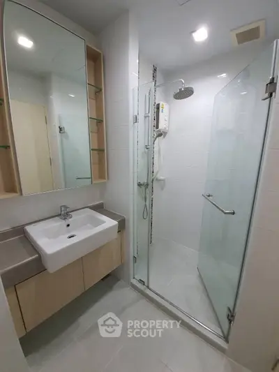 Modern bathroom with glass shower and sleek vanity in contemporary apartment