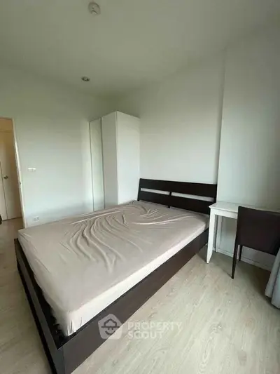 Modern bedroom with minimalist design featuring a sleek bed and wardrobe.