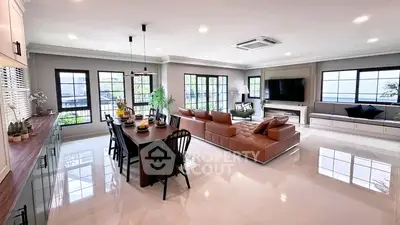 Spacious modern living room with elegant decor and large windows offering natural light.
