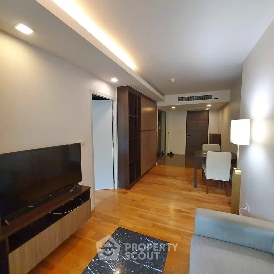 Modern living room with wooden flooring and sleek furniture in a contemporary apartment.