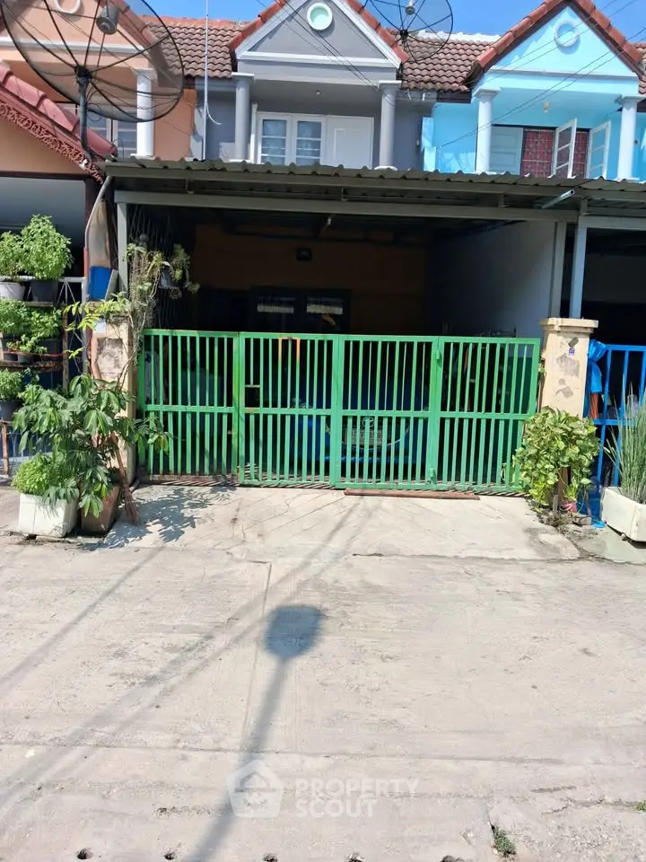 Charming townhouse with colorful facade and gated entrance, perfect for urban living.