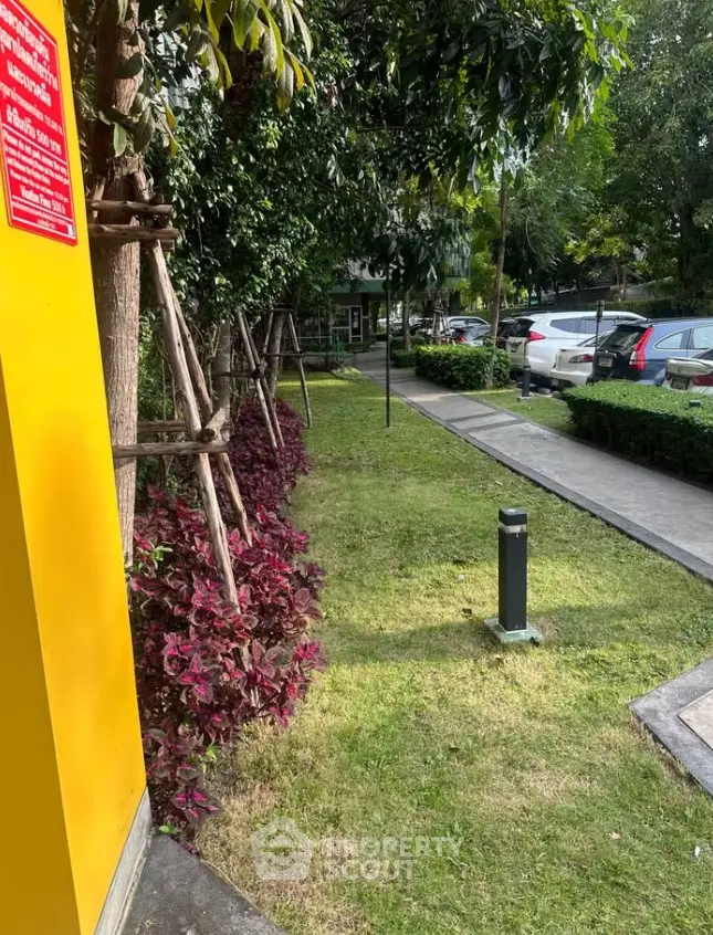 Charming garden area with lush greenery and convenient parking access in a serene residential setting.