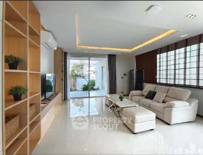 Spacious modern living room with elegant decor and large windows offering natural light.