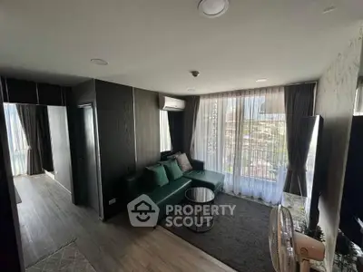 Modern living room with green sofa and large windows offering city views