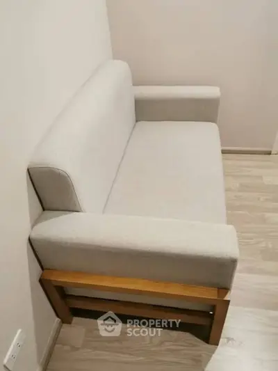 Cozy small sofa in a minimalist room with wooden flooring