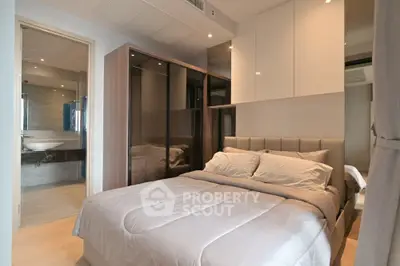 Modern bedroom with ensuite bathroom and sleek storage solutions