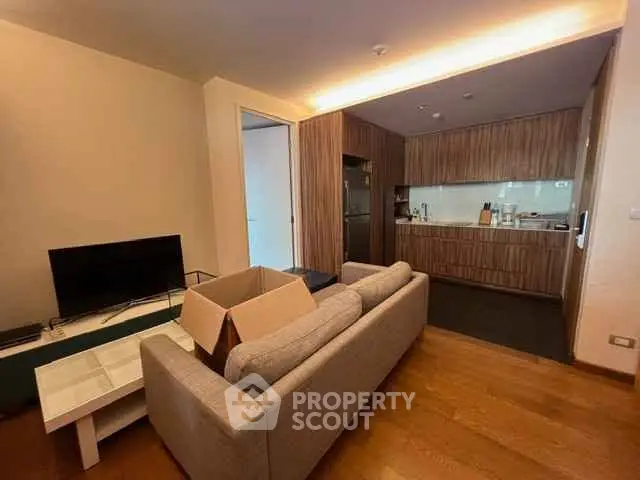 Modern open-plan living room with sleek kitchen and cozy seating area, perfect for urban living.