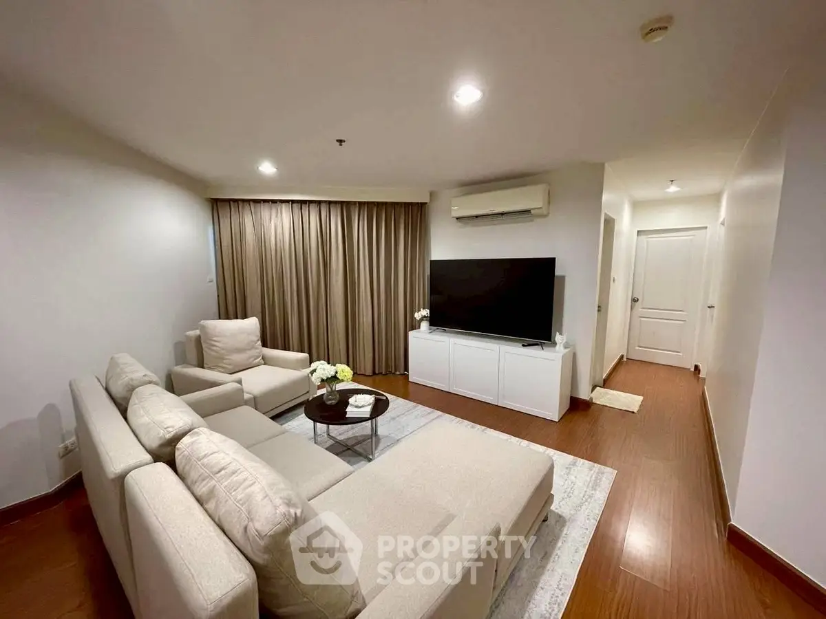 Spacious living room with modern furniture and large TV, perfect for relaxation and entertainment.
