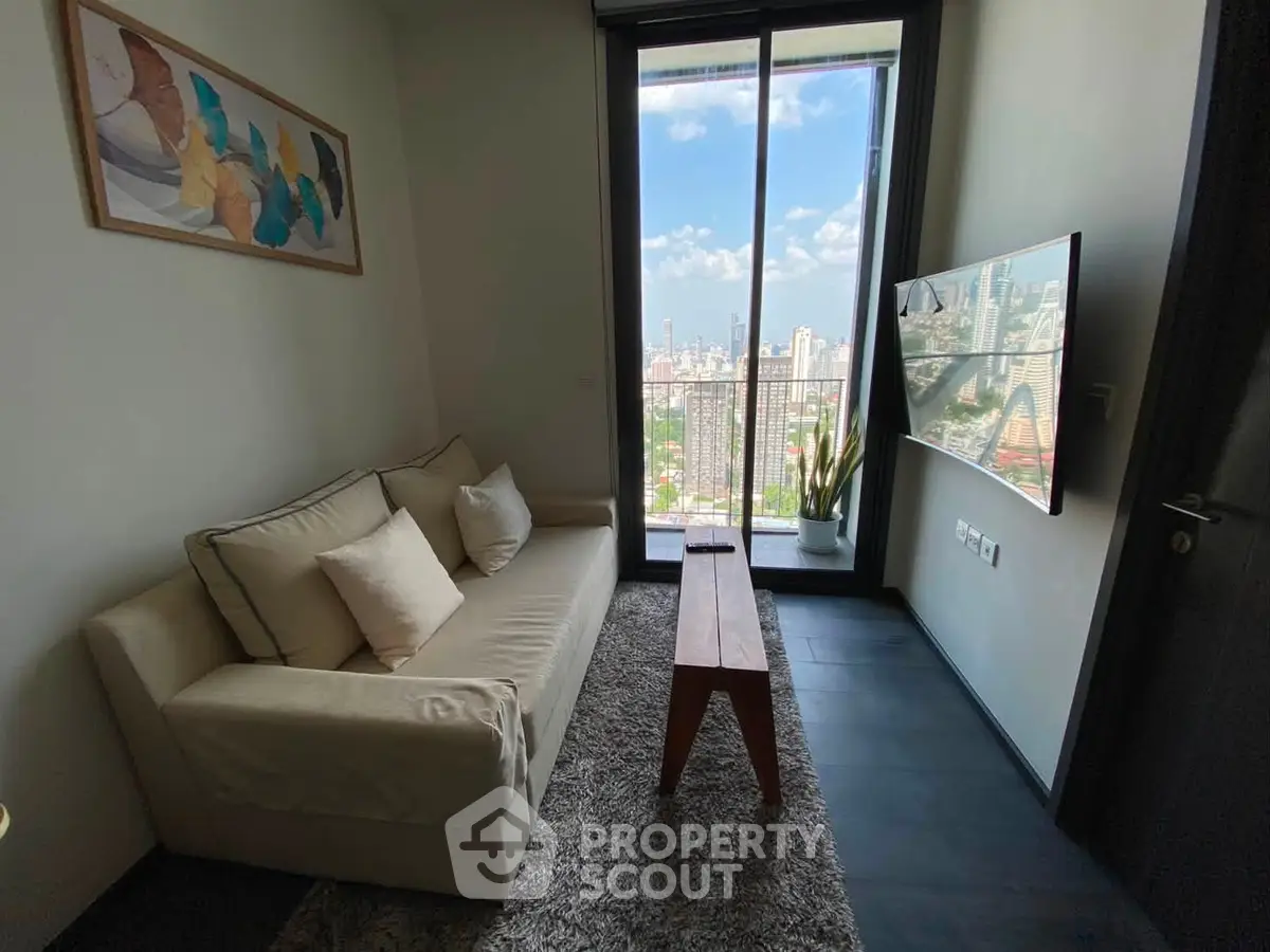 Modern living room with city view, cozy sofa, and wall-mounted TV in a high-rise apartment.