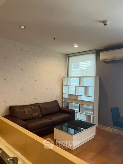 Cozy living room with leather sofa and modern shelving unit in a stylish apartment.