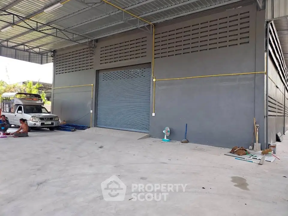 Spacious industrial warehouse with large roller door and ample parking space.