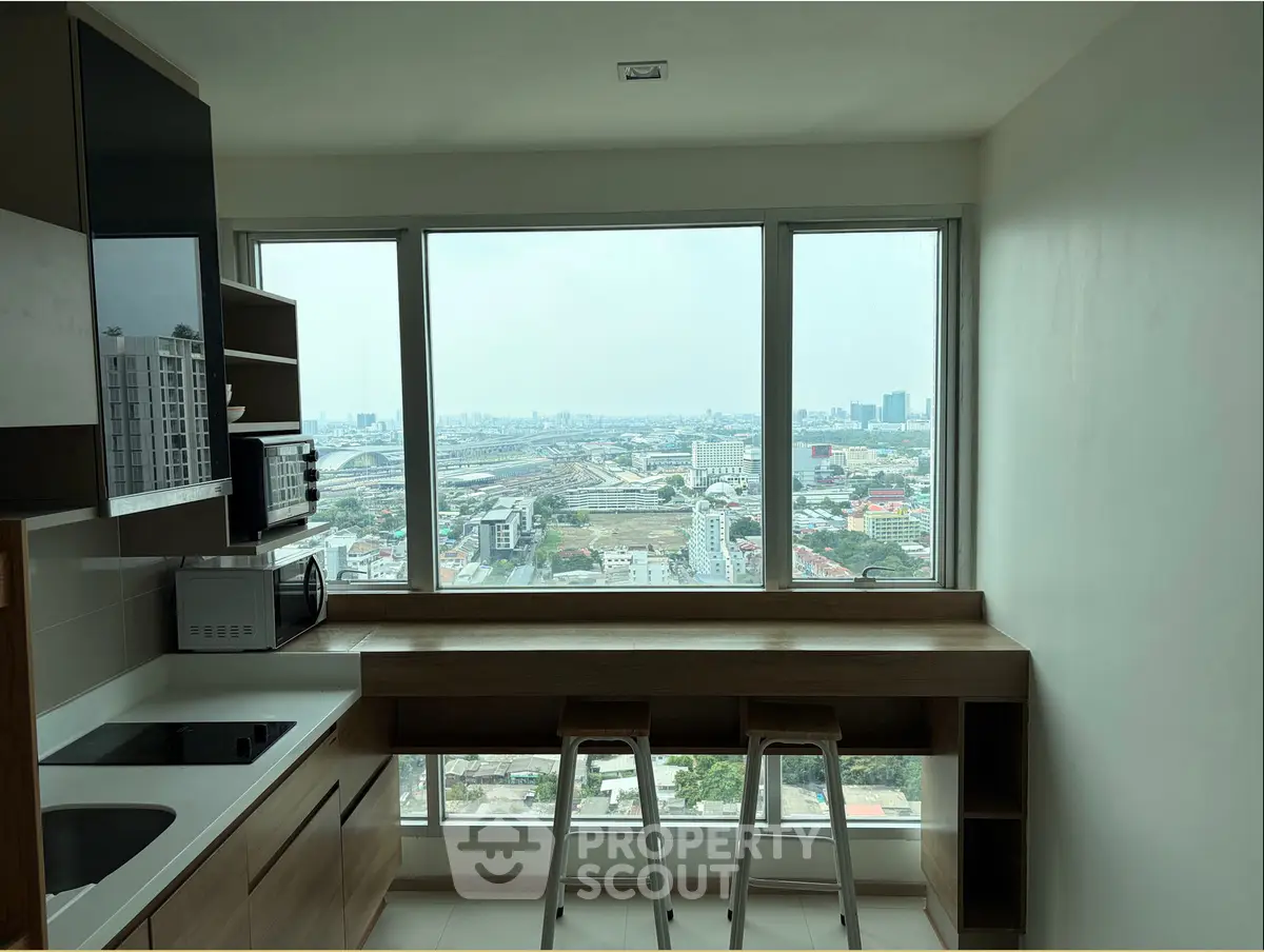 Modern kitchen with panoramic city view, featuring sleek appliances and a stylish breakfast bar.