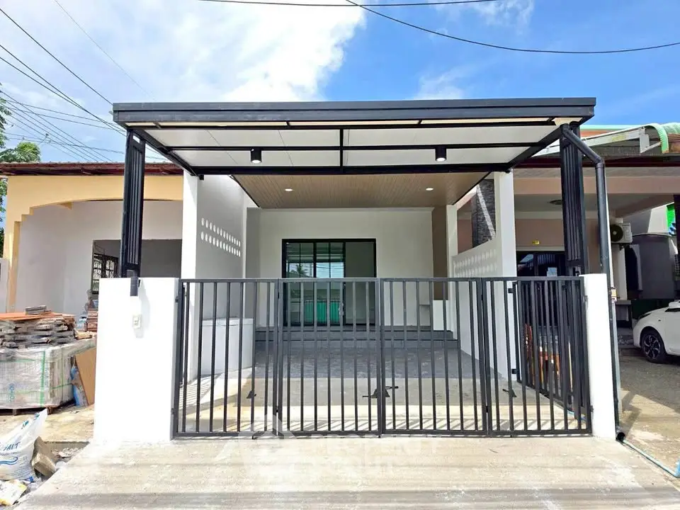 Modern house exterior with sleek metal gate and covered carport, perfect for contemporary living.
