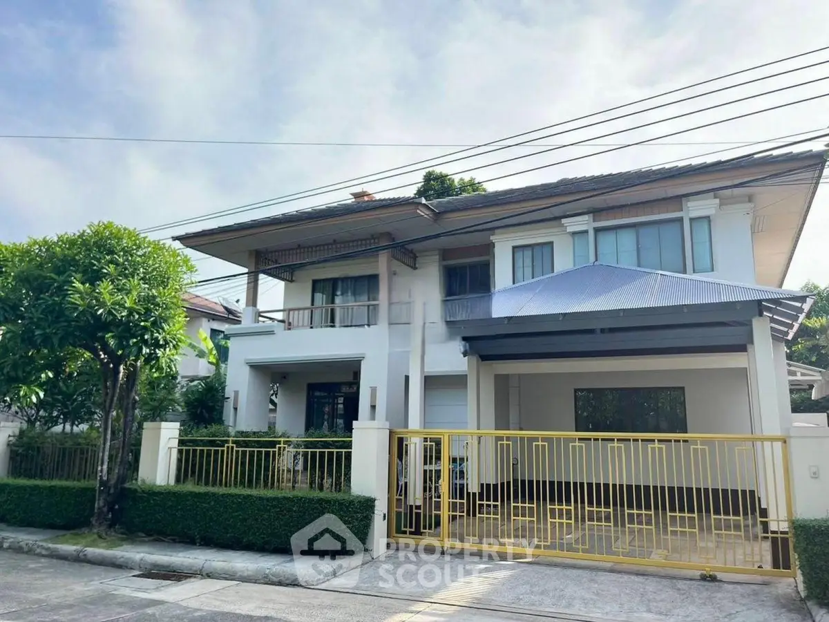 Stunning modern two-story house with gated entrance and lush greenery in a serene neighborhood.