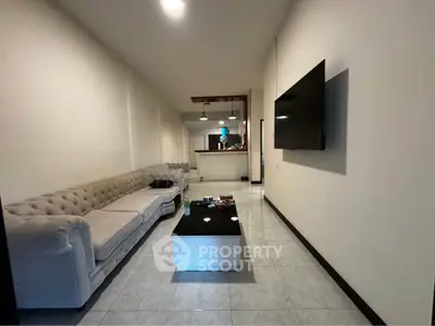 Spacious living room with modern decor and wall-mounted TV, ideal for relaxation and entertainment.