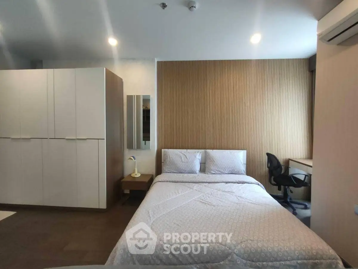 Modern bedroom with sleek design and workspace, perfect for urban living.