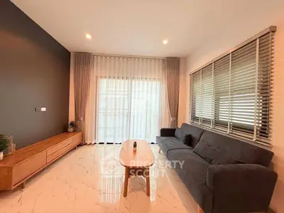 Modern living room with sleek furniture and large windows for natural light.