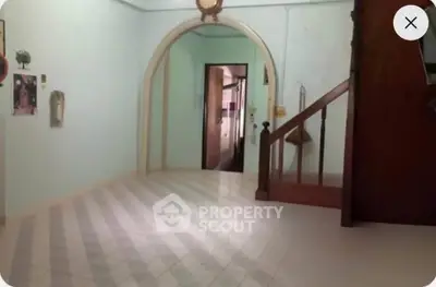 Spacious interior with unique archway and staircase, ideal for creative renovation.