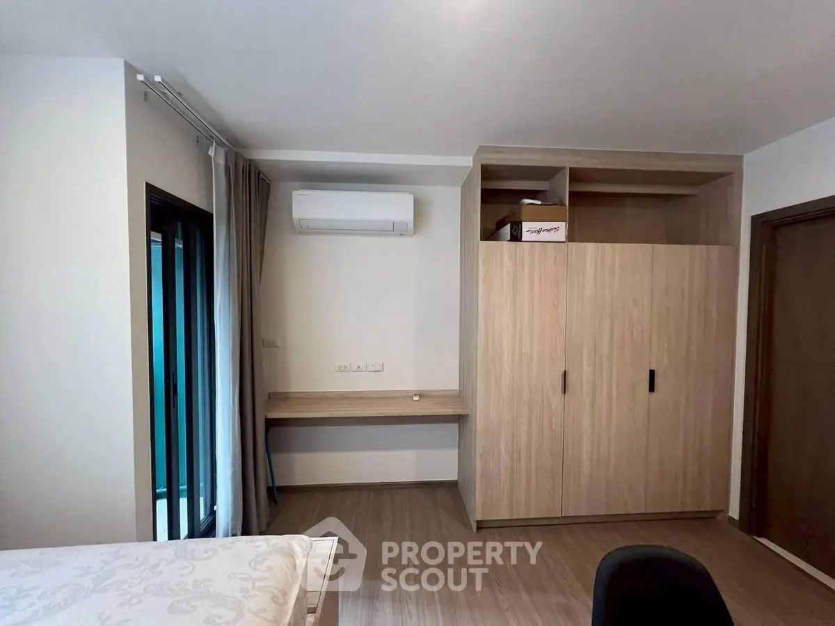Modern bedroom with built-in wardrobe and air conditioning in a stylish apartment.