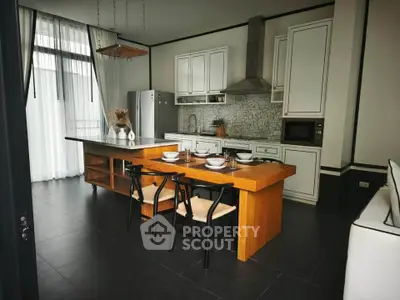 Modern kitchen with sleek design, featuring an open layout and stylish dining area.