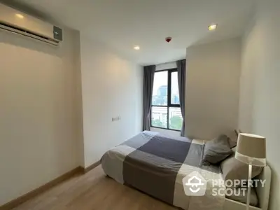 Modern bedroom with city view, featuring minimalist design and natural light.