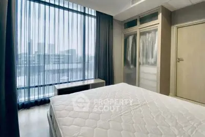 Modern bedroom with large window and stylish wardrobe in urban apartment