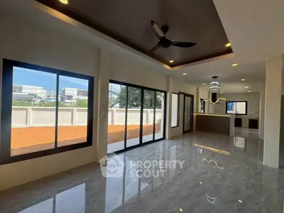 Spacious modern living room with large windows and sleek tile flooring