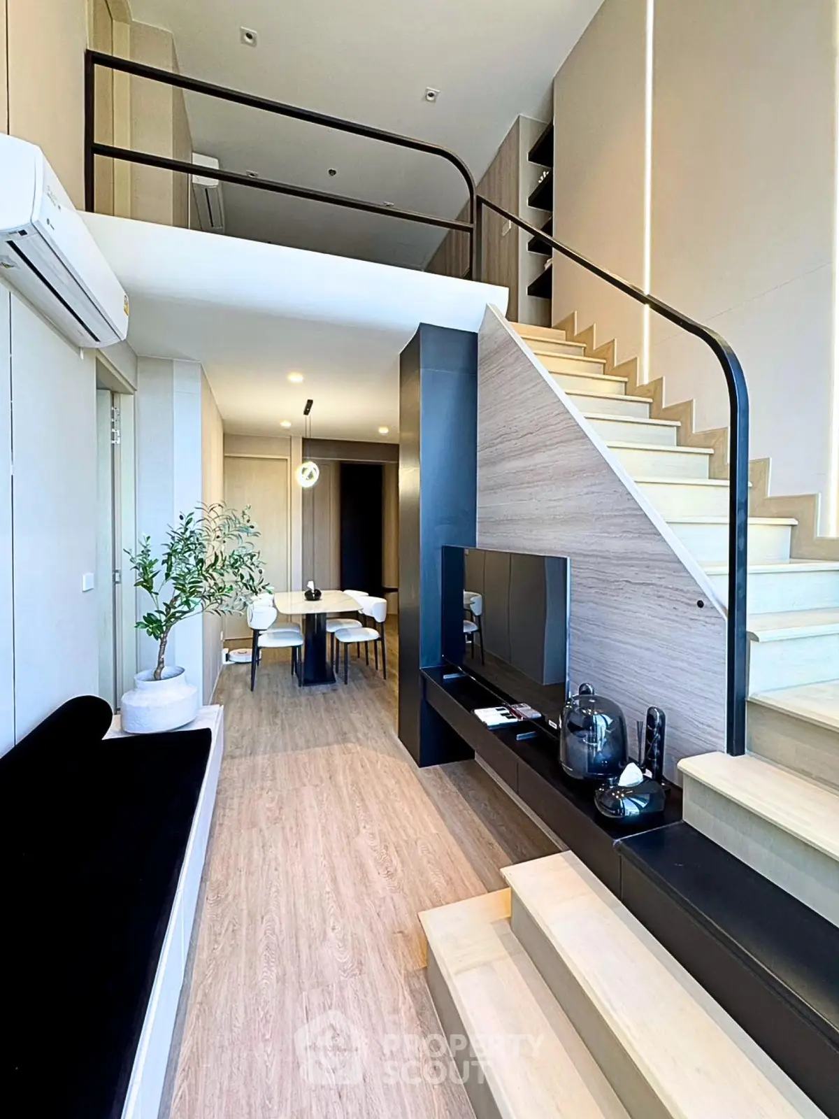 Modern duplex living room with stylish staircase and open dining area