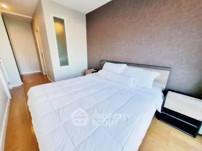 Spacious bedroom with modern decor and natural light, featuring a comfortable bed and stylish furnishings.