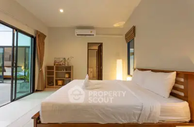 Spacious bedroom with modern decor and large windows opening to a serene view, perfect for relaxation.