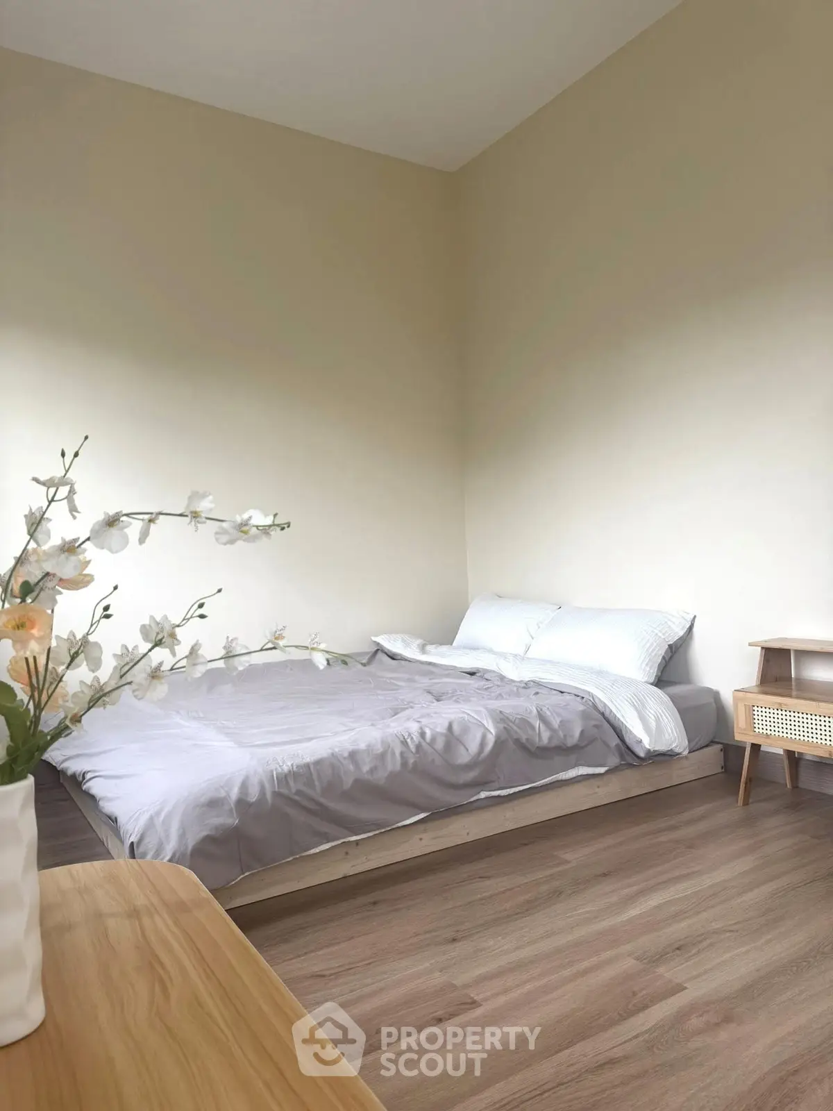 Cozy minimalist bedroom with wooden flooring and soft lighting