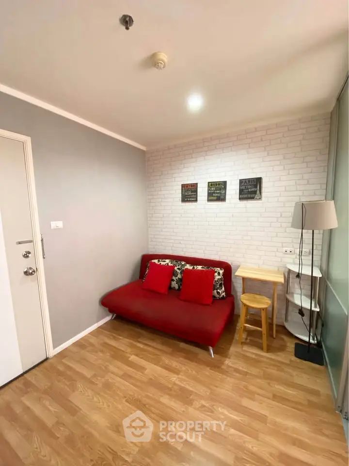 Cozy living room with red sofa and modern decor, perfect for relaxation.