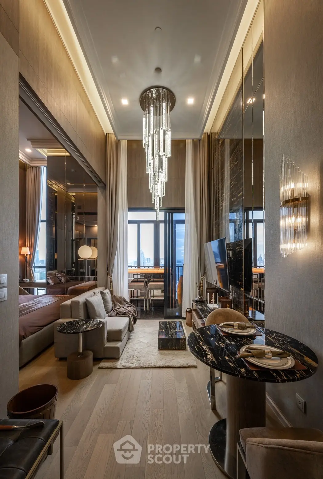 Luxurious modern living room with elegant chandelier and open layout, featuring a stunning city view.