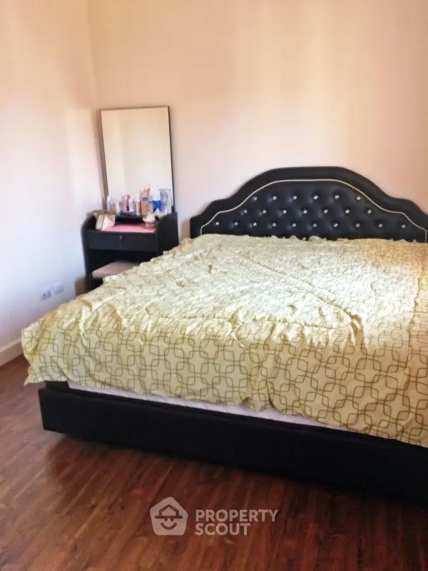 Cozy bedroom with elegant bed and wooden flooring, perfect for relaxation.