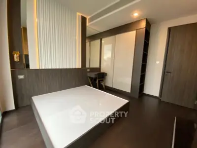Modern bedroom with sleek dark wood flooring and built-in wardrobe