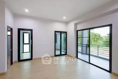 Spacious modern room with large windows and balcony access