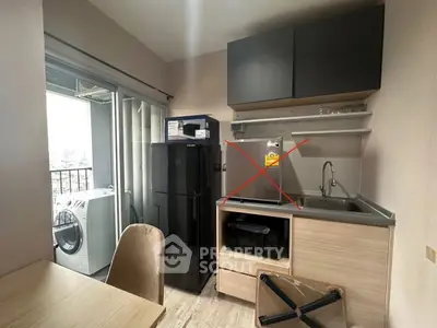 Modern kitchen with open layout and balcony view, featuring sleek appliances and stylish cabinetry.