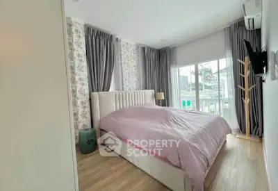 Spacious bedroom with elegant decor and large windows offering natural light and city views.