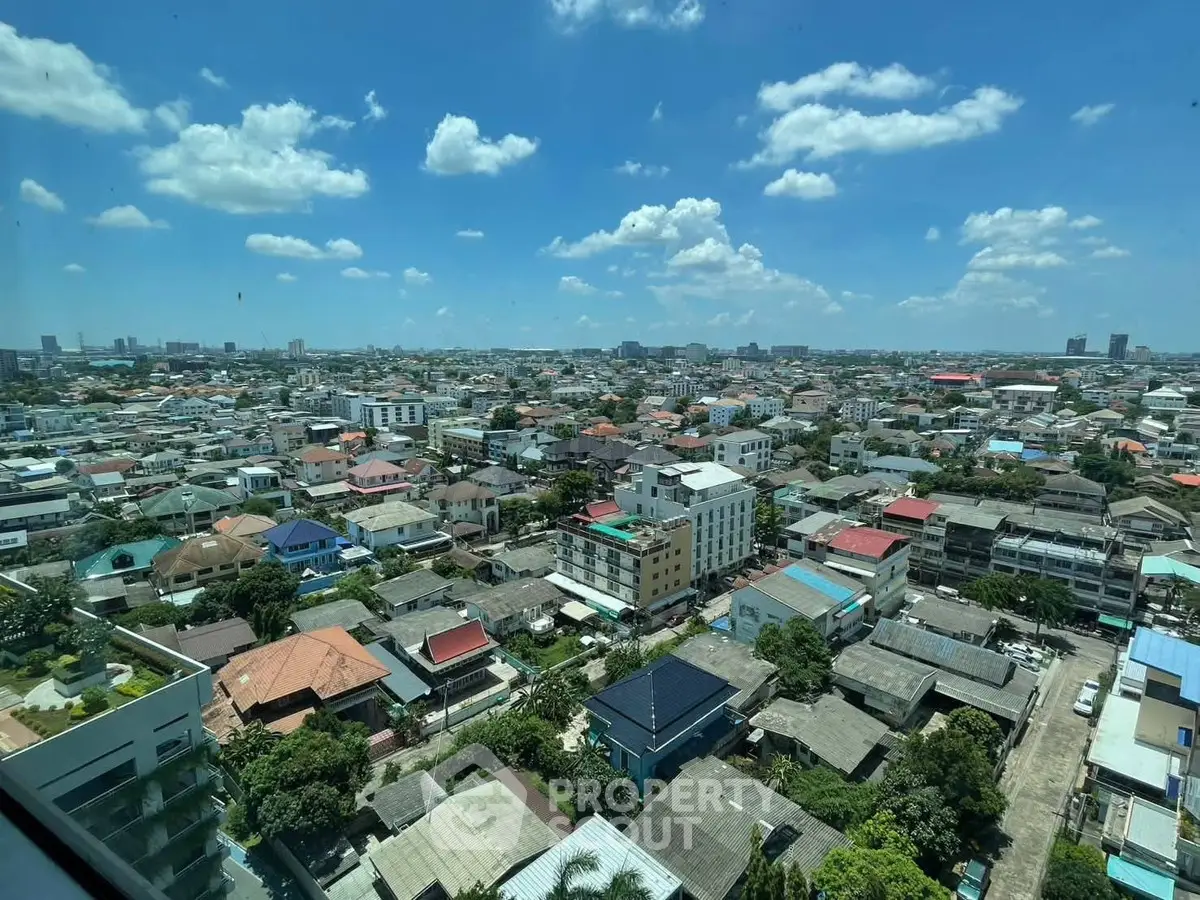 Stunning cityscape view from high-rise building window showcasing urban landscape under clear blue sky.