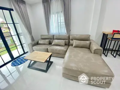 Spacious living room with modern leather sectional sofa and natural light