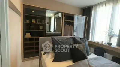 Modern bedroom with stylish decor and large window for natural light.