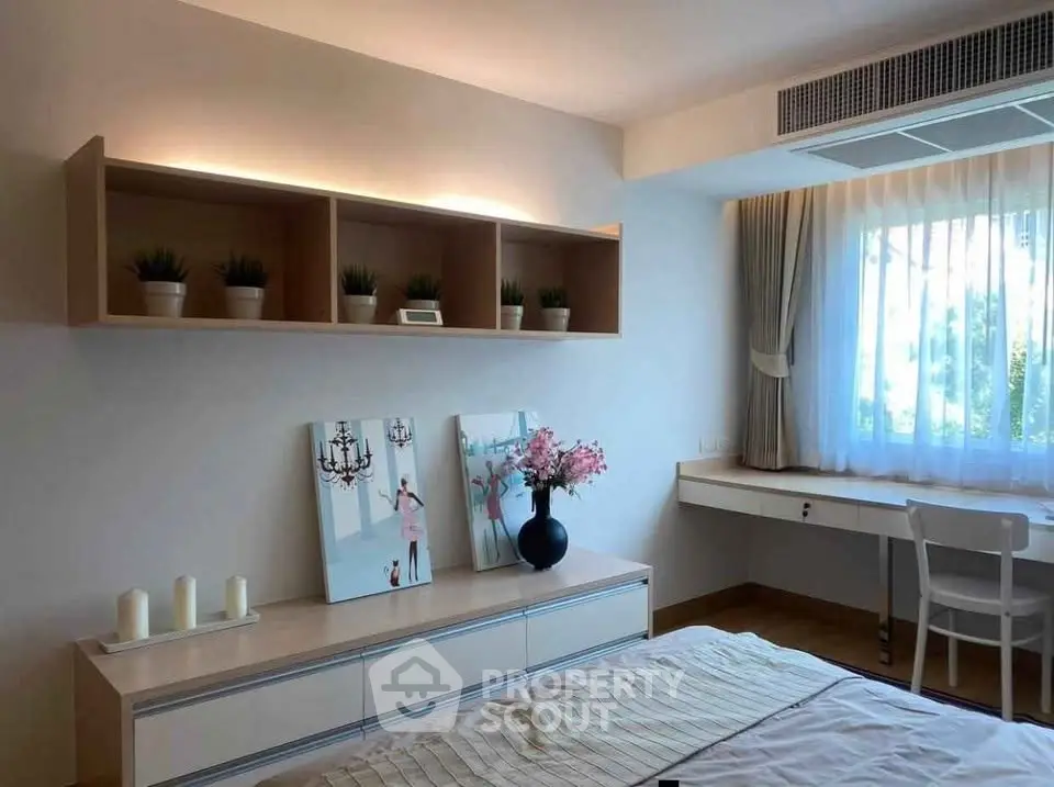 Charming bedroom with modern decor, natural light, and stylish shelving.