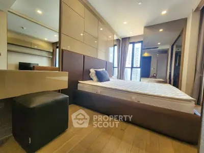 Luxurious modern bedroom with large windows and elegant furnishings in a high-rise apartment.