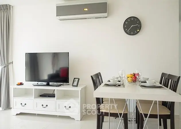 Modern living room with dining area, featuring sleek furniture and a wall-mounted air conditioner.