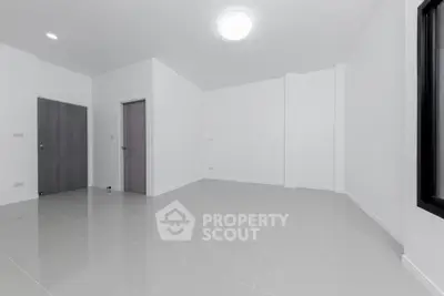 Spacious empty room with modern tile flooring and minimalist design.
