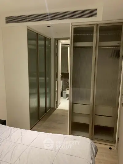 Modern bedroom with sliding glass closet doors and en-suite bathroom