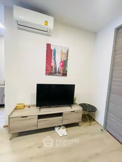 Modern living room with stylish TV stand, air conditioning, and chic decor in a cozy apartment.