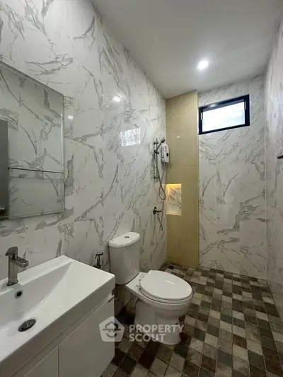 Modern bathroom with marble walls and sleek fixtures in a contemporary home.